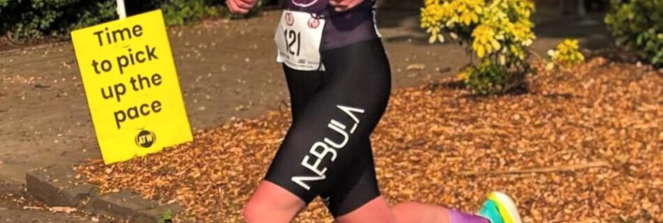 Laura running with a sign saying time to pick up the pace