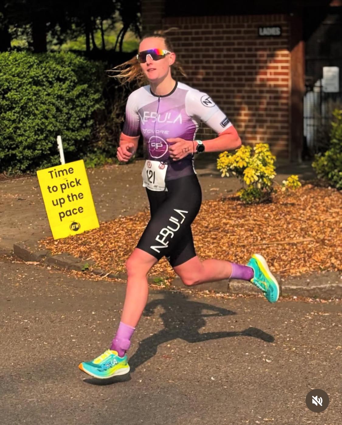 Laura running with a sign saying time to pick up the pace